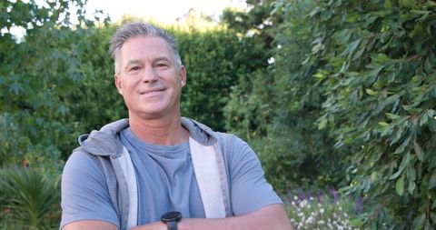 Man Standing in Lush Garden Leisurely Sporting Smartwatch