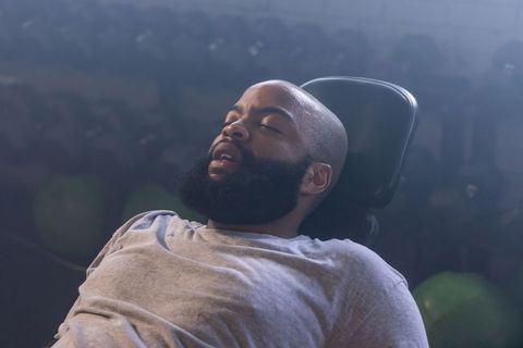 African american man resting on gym bench headrest post-workout recovery cooldown calm