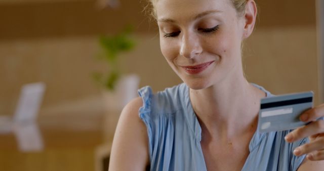 Smiling Woman Holding Credit Card in Office Environment - Download Free Stock Images Pikwizard.com