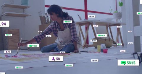 Contemporary artist painting in studio with social media overlays