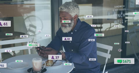 Elderly Man Engaged in Social Media at Outdoor Cafe