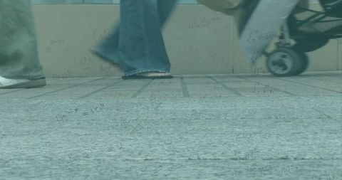 Urban pedestrian scene with math formula overlay on pavement