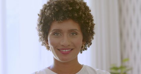 Radiant Woman with Curly Hair Brightens Joyful Occasion