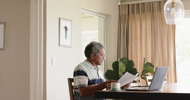 Senior Man Analyzing Documents at Home Office with Laptop - Download Free Stock Images Pikwizard.com