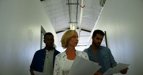 Diverse professionals collaborating in office hallway