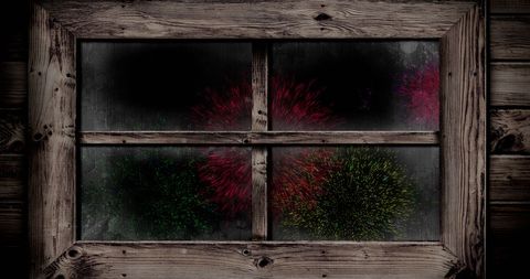 Colorful fireworks viewed through rustic wooden window frame
