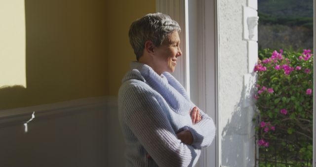 Smiling senior woman enjoying sunny view through window - Download Free Stock Images Pikwizard.com