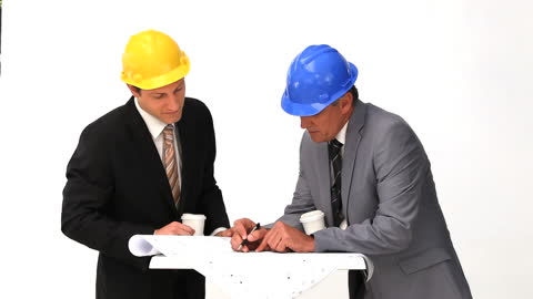 Engineers Reviewing Building Plans in Meeting