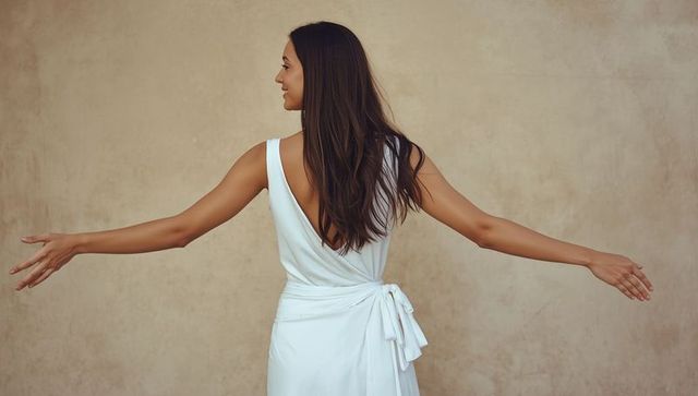 Elegant woman welcoming with graceful gesture in white dress