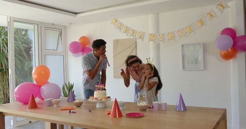 Family Celebrates Birthday with Cake and Balloons at Home