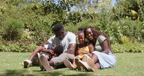 Family Bonding Outdoors in Lush Greenery Smiling Together