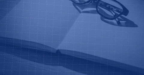 Stylish Glasses on Open Notebook with Grid Overlay for Creative Professional Setup