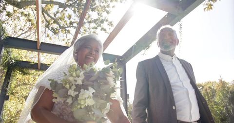 Joyful Senior Couple Celebrating Marriage in Sunlit Garden
