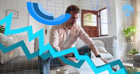 Working man analyzing financial data on laptop in modern living room with HUD overlay