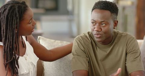 Couple having serious conversation on sofa showing emotional support and honest connection