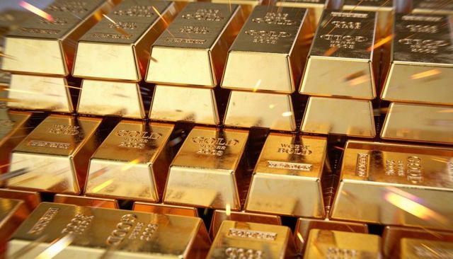 Shimmering gold bars stacking in vault reflecting warm light and hallmarks