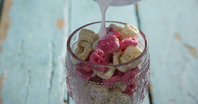 Pouring Milk Over Colorful Cereal in Glass Bowl on Wooden Table - Download Free Stock Images Pikwizard.com