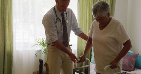 Senior patient assisted by doctor with walker at retirement home