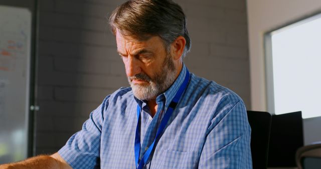 Senior Man in Office Wearing Plaid Shirt Concentrating on Work - Download Free Stock Images Pikwizard.com