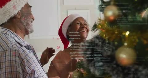 Elderly Couple Laughing While Decorating Christmas Tree