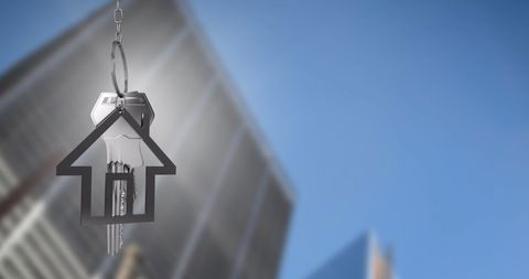 Real Estate Concept with Key and House Over City Skyline