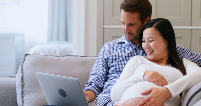 Expecting Parents Relaxing on Couch Using Laptop - Download Free Stock Images Pikwizard.com