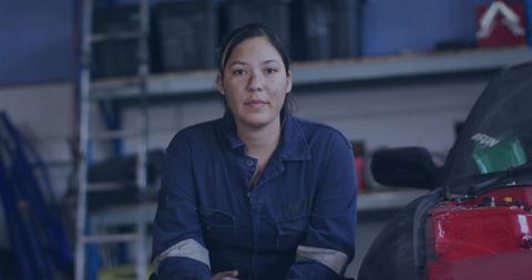 Female Mechanic Inspecting Car Engine in Workshop