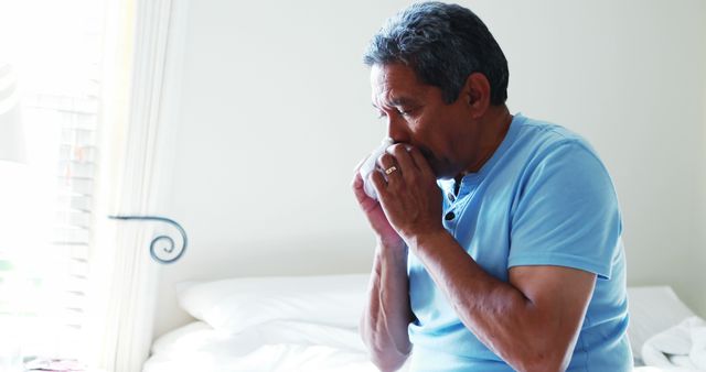 Senior Man Blowing Nose While Sitting on Bed - Download Free Stock Images Pikwizard.com