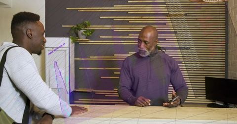 Staff and client discussing at modern minimalist reception desk during friendly transaction