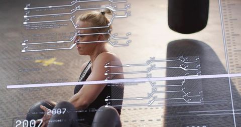 Female athlete resting with medicine ball and augmented reality fitness data overlay
