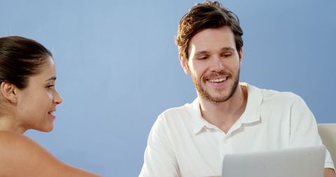 Young adults discussing project using laptop in relaxed setting