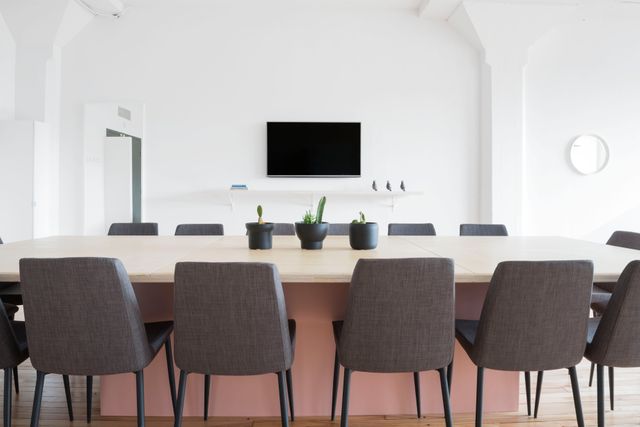 Conference room featuring modern design with black chairs and minimalist decor, perfect for depicting contemporary office environments, teamwork, and professional gatherings. Ideal for business websites, office design portfolios, and corporate training materials.
