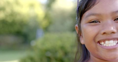 Joyful girl outdoors with missing tooth on sunny day