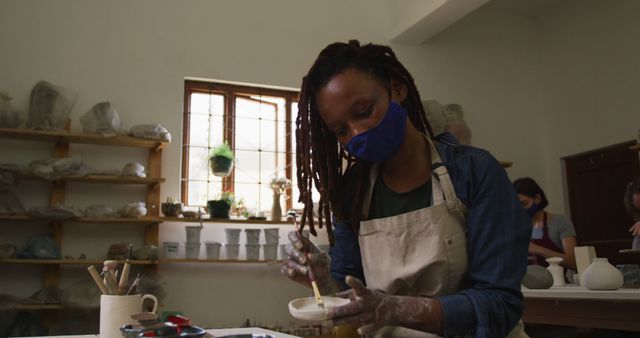 Artist with Dreadlocks Glazing Pottery in Artisan Workspace - Download Free Stock Images Pikwizard.com