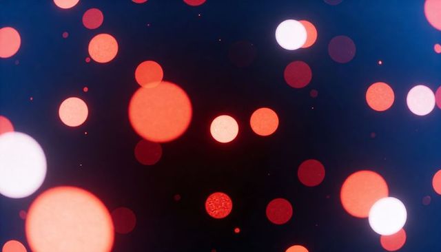 Glowing red and pink bokeh orbs creating dreamy night light background with soft grain
