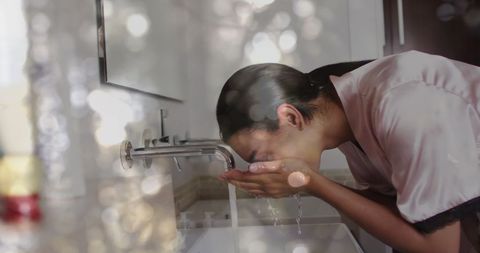 Woman Washing Face with Magical Light Effects