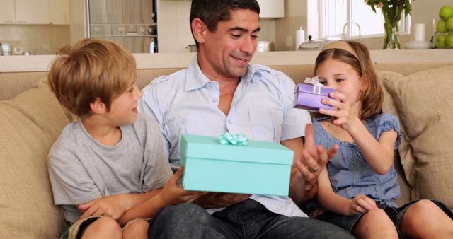 Father Enjoys Opening Gifts with Children on Couch at Home - Download Free Stock Images Pikwizard.com