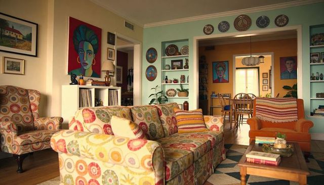 Colorful eclectic living room with patterned sofa, mint walls and wooden coffee table