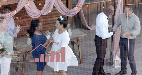 Guests mingling and greeting at outdoor wedding on wooden deck with data chart overlay