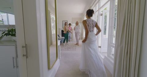 Bride trying on wedding dress in lovely bridal studio setting