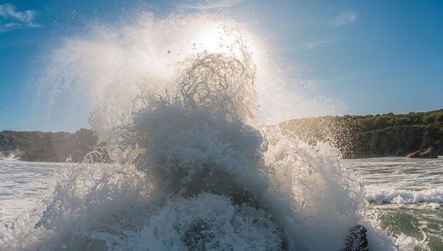 Dynamic ocean wave crashing against coastal rock