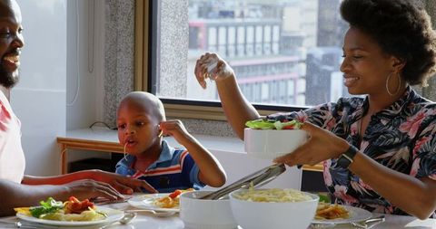 Happy african american family enjoying meal together at home
