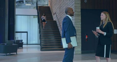 Corporate Professionals Conversing in Modern Office Lobby