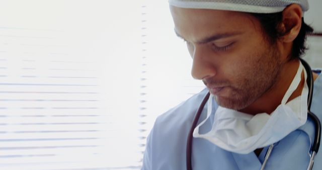 Focused Male Doctor Wearing Scrubs and Surgical Mask in Hospital Room - Download Free Stock Images Pikwizard.com