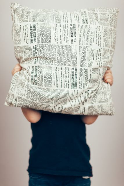 Child Hiding Face with Newspaper Print Pillow - Download Free Stock Images Pikwizard.com