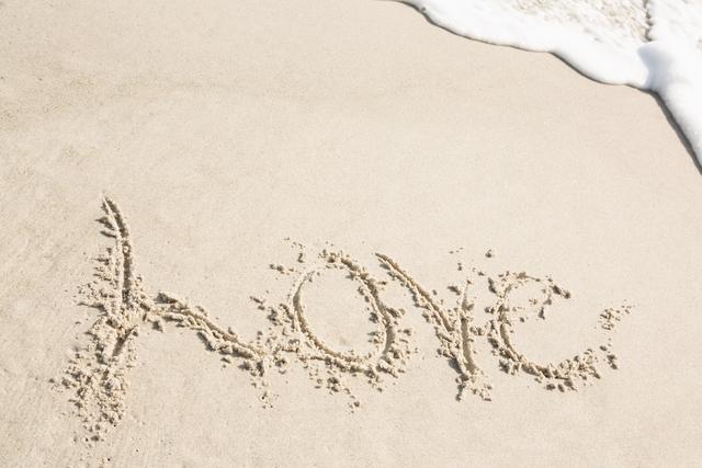 Love written on sand at beach with gentle ocean waves approaching. Perfect for themes of romance, vacation, relaxation, and nature. Ideal for travel brochures, romantic greeting cards, and inspirational posters.
