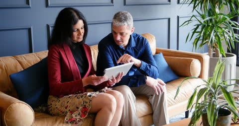 Professional Discussion with Tablet on Modern Sofa