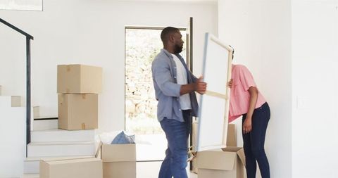 Couple Unpacking and Decorating New Home with Enthusiasm