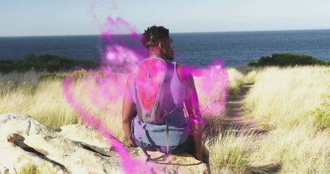 Contemplative Hiker Overlooking Ocean with Mystical Purple Mist