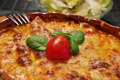 Delicious homemade lasagna garnished with basil and tomato